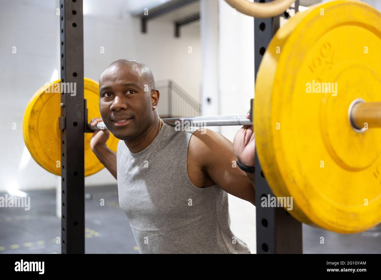 Ritratto di atleta maschile nero che fa allenamento di peso in palestra. Concetto di salute e benessere. Foto Stock