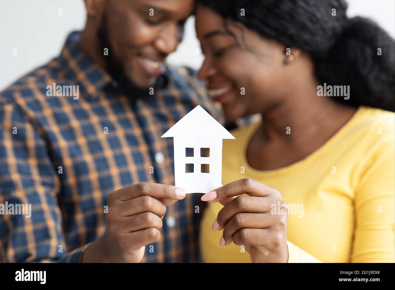 Coniugi afroamericani che tiene in mano Cutout Paper House Figure Foto Stock