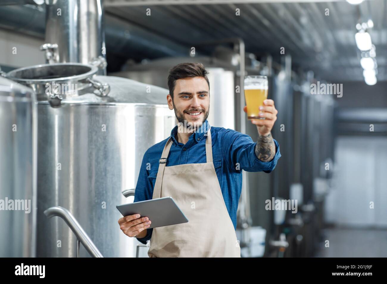 Controllo di qualità delle bevande alcoliche nella produzione e nel lavoro in birreria che ispeziona la qualità della produzione in fabbrica Foto Stock