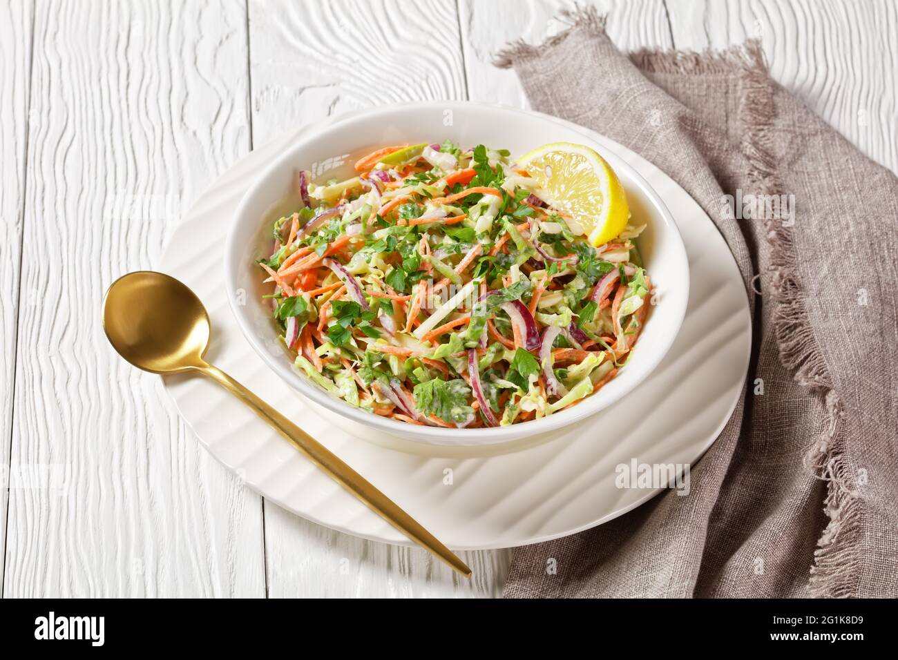 insalata fresca di insalata di insalata di insalata di insalata di insalata estiva con leggero yogurt in una ciotola bianca su un tavolo di legno Foto Stock