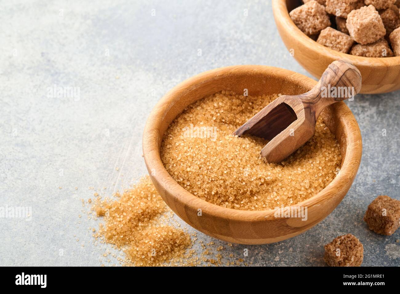 Canna zucchero cubo in bambù ciotola su sfondo grigio tavolo cemento. Vista dall'alto. Foto Stock