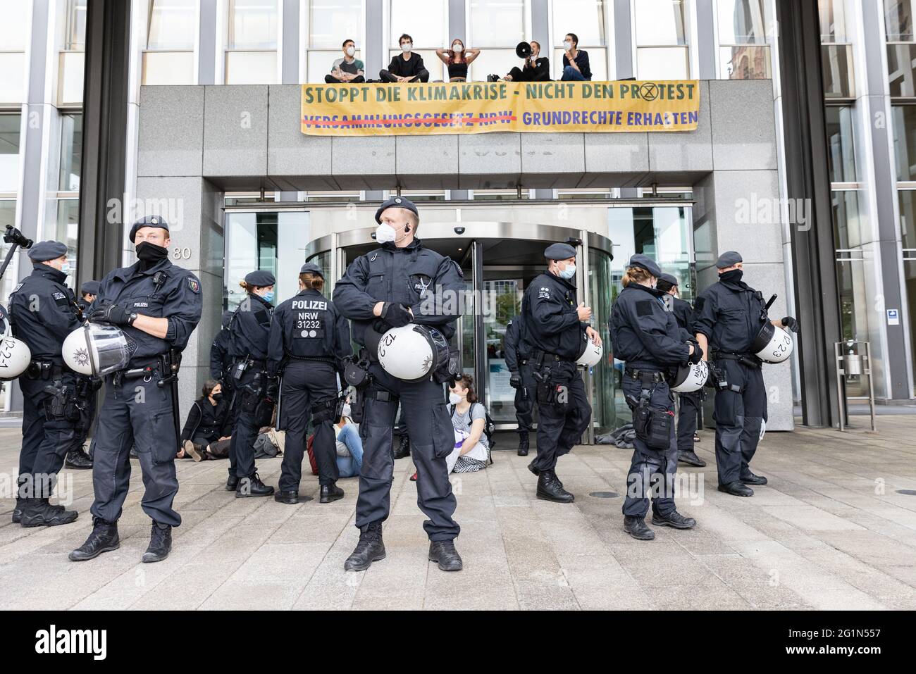 Duesseldorf, Germania. 07 giugno 2021. Attivisti ambientali del gruppo Extention Rebellion protestano all'ingresso principale del Ministero dell'interno dell'NRW. I dimostranti si sono seduti davanti all'ingresso e si sono arrampicato sul tetto del portale d'ingresso, dove hanno svelato un cartello: "Ferma la crisi climatica, non la protesta". Credit: Marcel Kusch/dpa/Alamy Live News Foto Stock