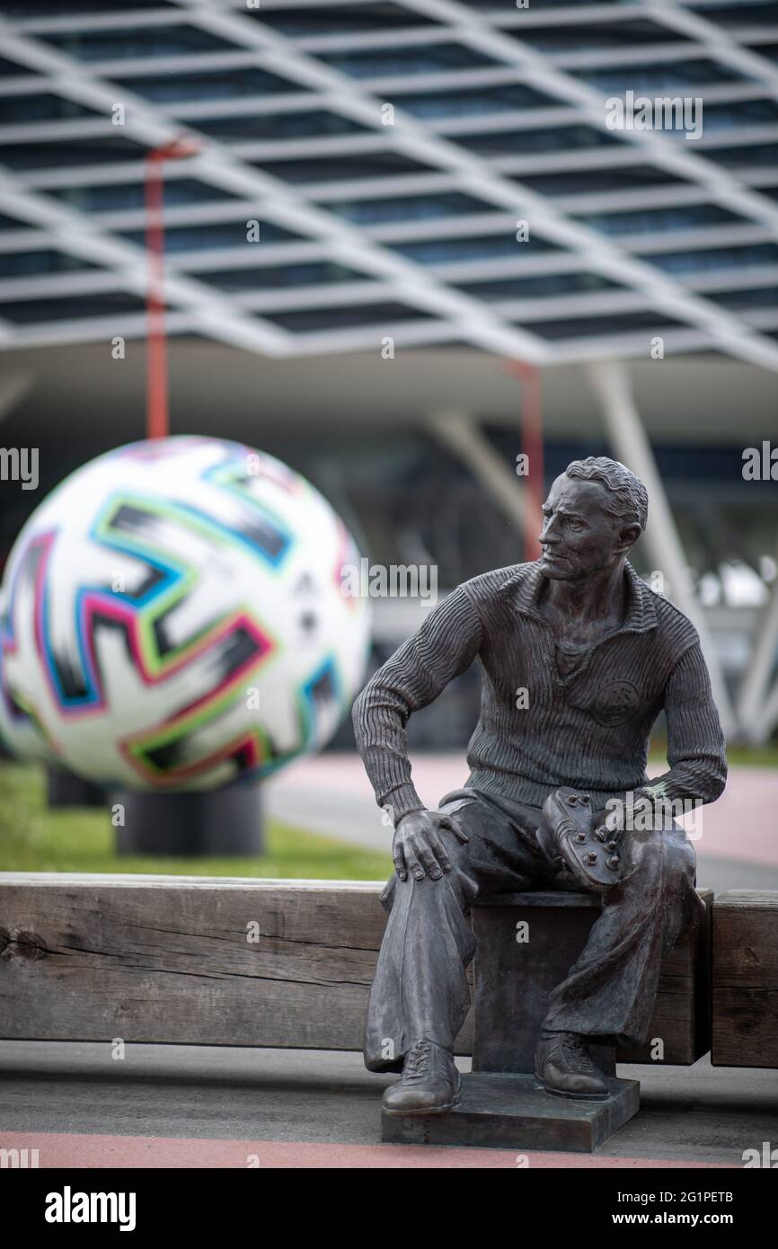 Herzogenaurach, Germania. 07 giugno 2021. Una statua del fondatore Adolf 'Adi' Dassler è stata eretta di fronte all'edificio degli uffici 'Arena' sui terreni di adidas produttori di articoli sportivi. Sullo sfondo c'è un pallone ufficiale oversize 'Uniforia' dell'EURO 2020. La squadra nazionale tedesca di calcio e il personale di supporto soggiorneranno presso il "Home Ground" presso la sede del partner DFB adidas per tutta la durata del Campionato europeo. Credit: Daniel Karmann/dpa/Alamy Live News Foto Stock