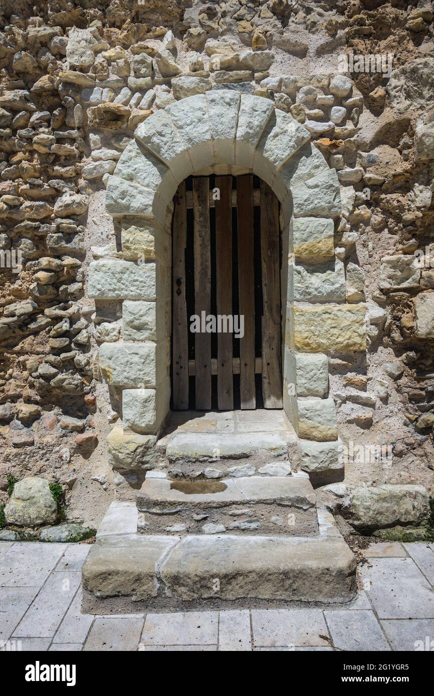 Vecchia porta ad arco in pietra nel muro della chiesa abbaziale di Saint Pierre, Beaulieu-lès-Loches, Indre-et-Loire (37), Francia. Foto Stock