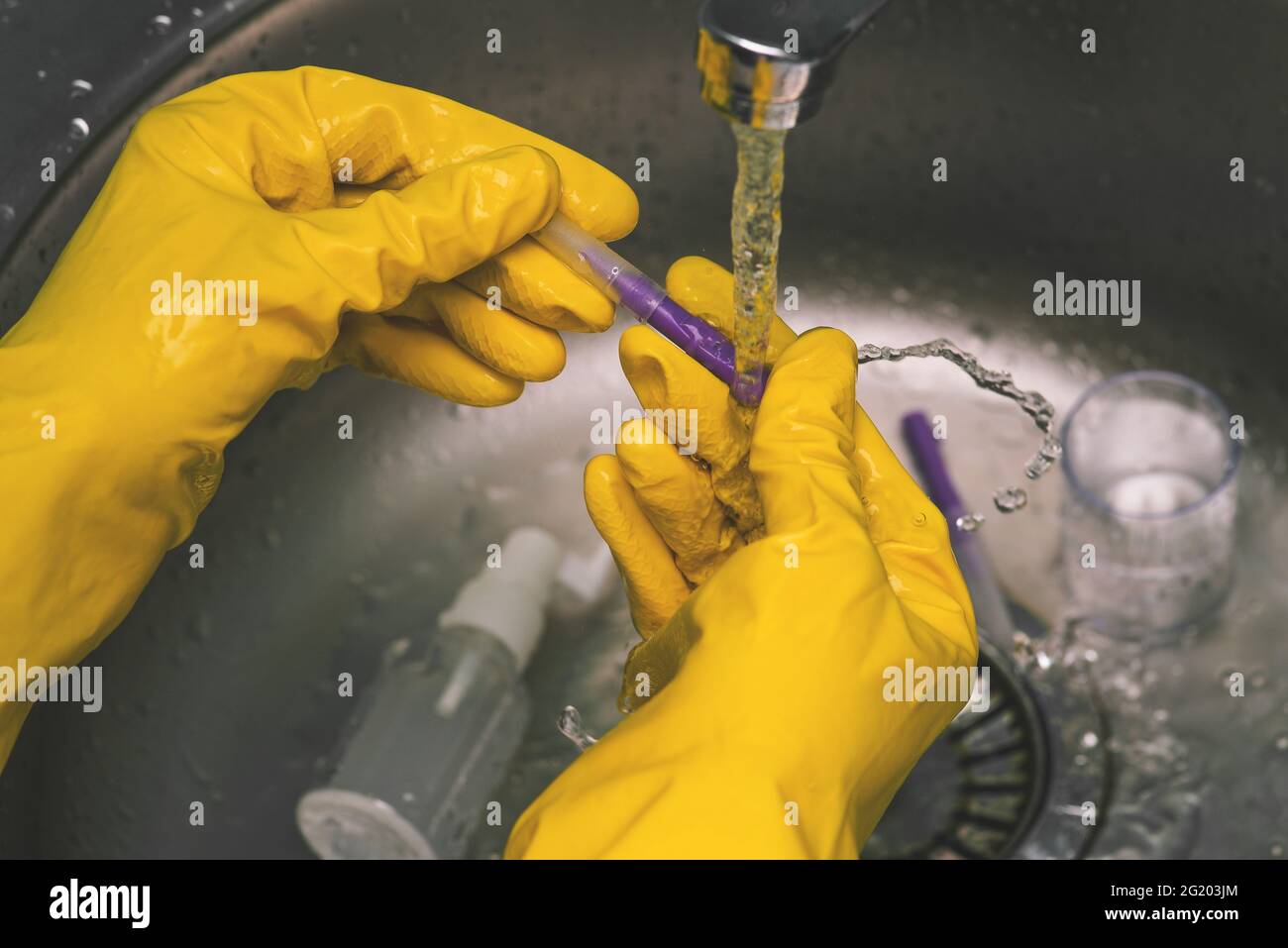 Esperimenti e esperimenti in laboratorio. Uno scienziato in guanti gialli conduce analisi chimiche e test. Il lavoro di un medico, estetista e. Foto Stock