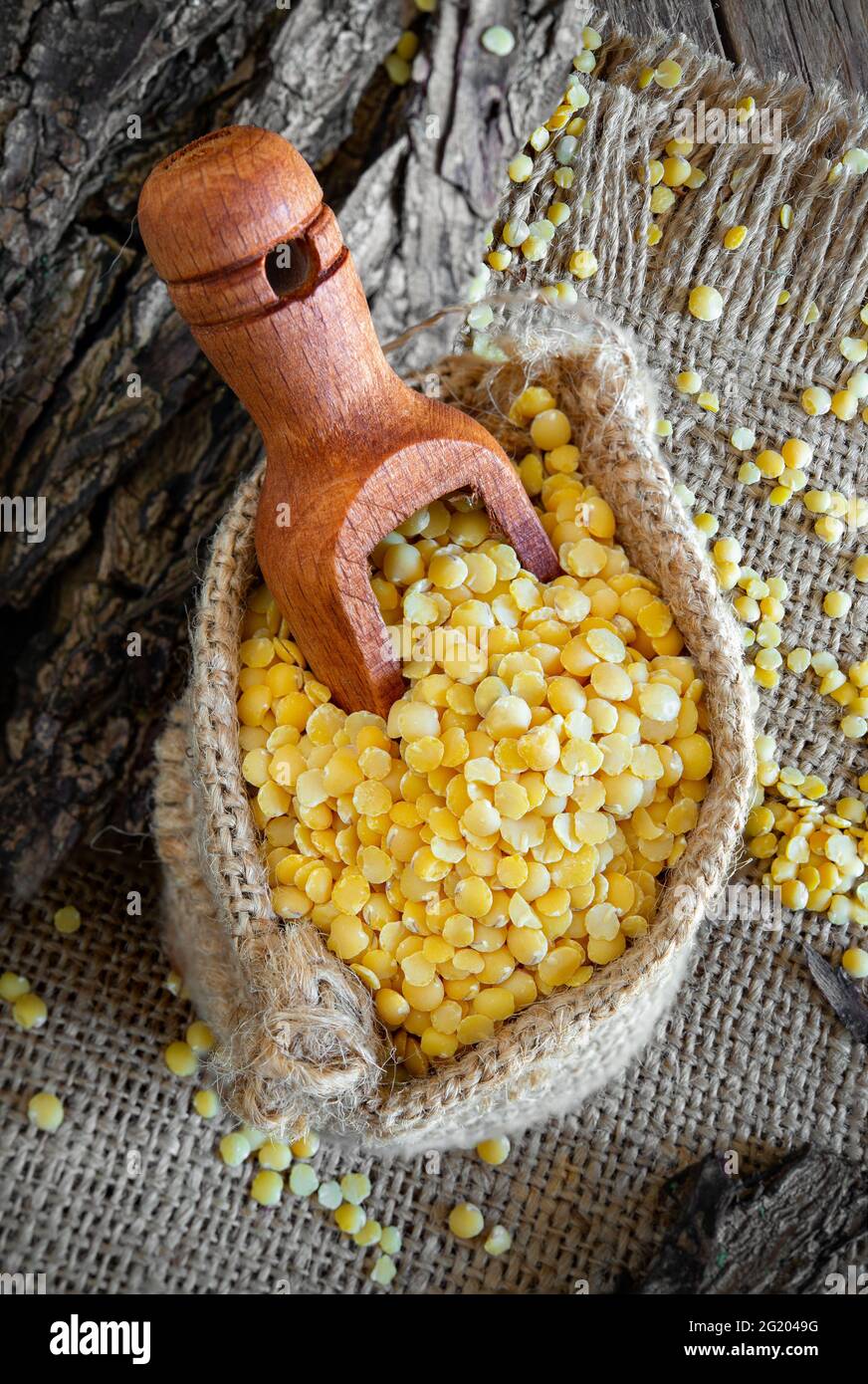 ciotola di bambù con lenticchie gialle su tavolo di legno Foto Stock