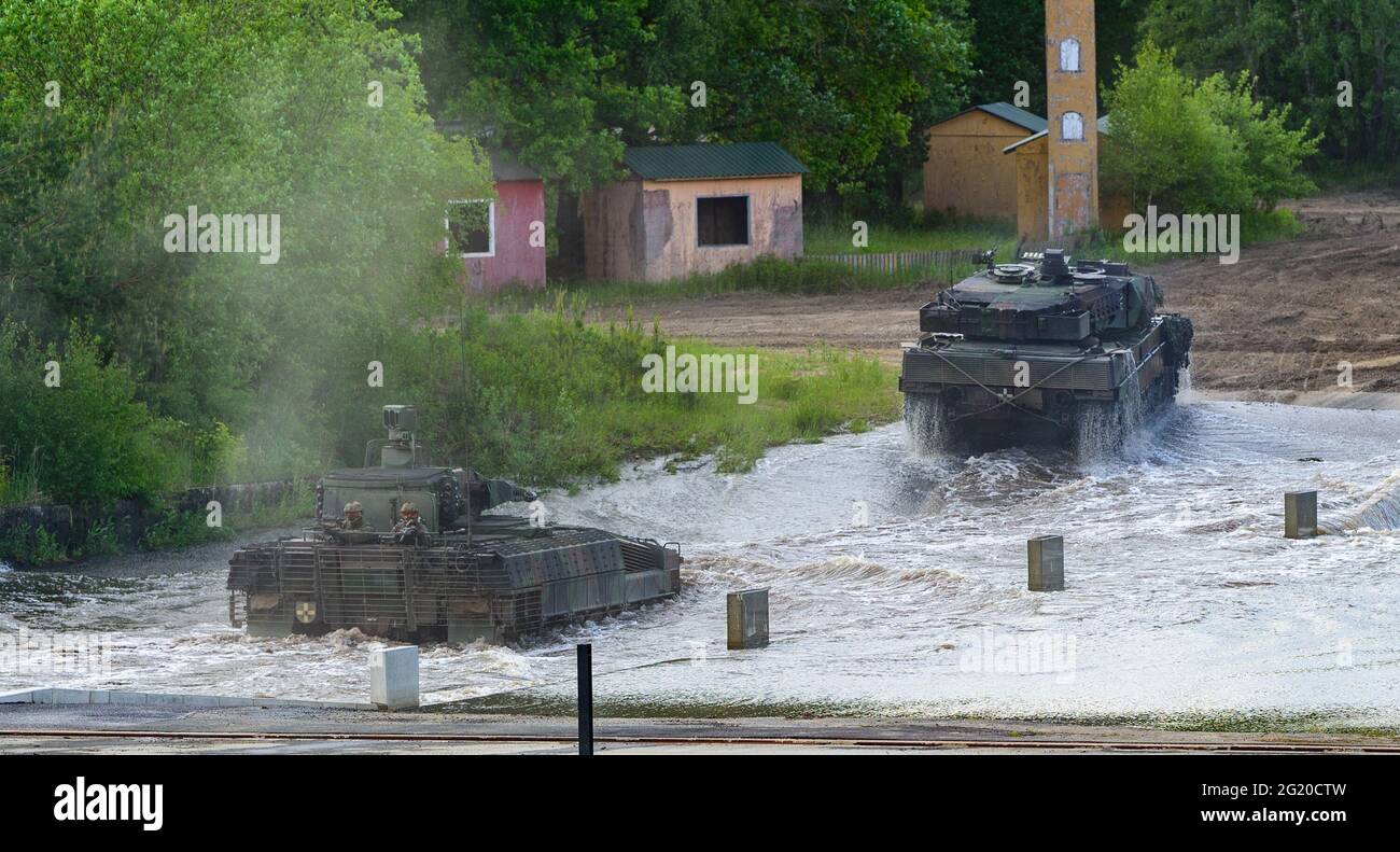 Munster, Germania. 02 giugno 2021. Un veicolo da combattimento di fanteria  Bundeswehr Puma (l) e un carro armato principale di battaglia Bundeswehr  Leopard 2A6 attraversano una piscina d'acqua durante una dimostrazione di