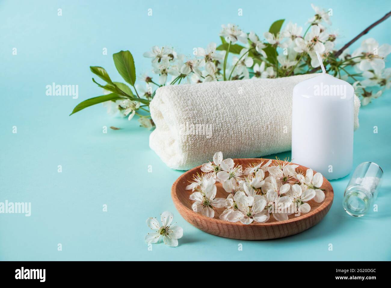 Prodotti naturali biologici di bellezza per spa e aromaterapia. Olio essenziale aromatico, candele e un asciugamano su sfondo blu. Concetto di relax, luogo Foto Stock