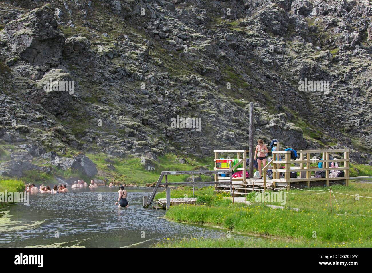 I turisti che nuotano nelle terme calde nella valle di Landmannalaugar, nella riserva naturale di Fjallabak, nel parco naturale vicino a Hekla / Hecla in estate, Sudurland, Islanda Foto Stock