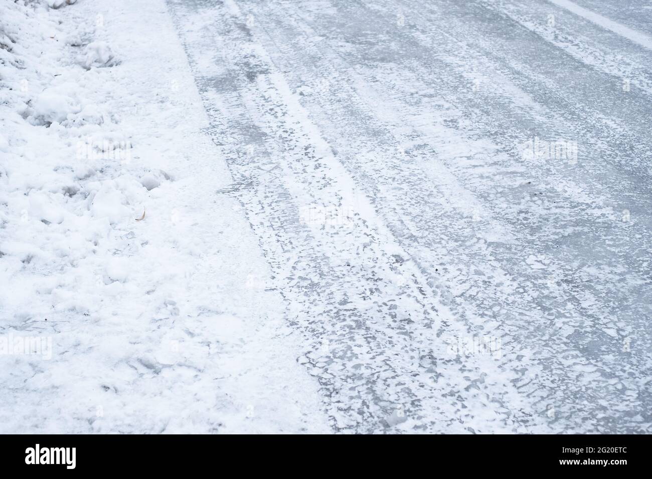 Strada ghiacciata e scivolosa coperta di ghiaccio durante l'inverno. Condizioni atmosferiche difficili. Foto Stock