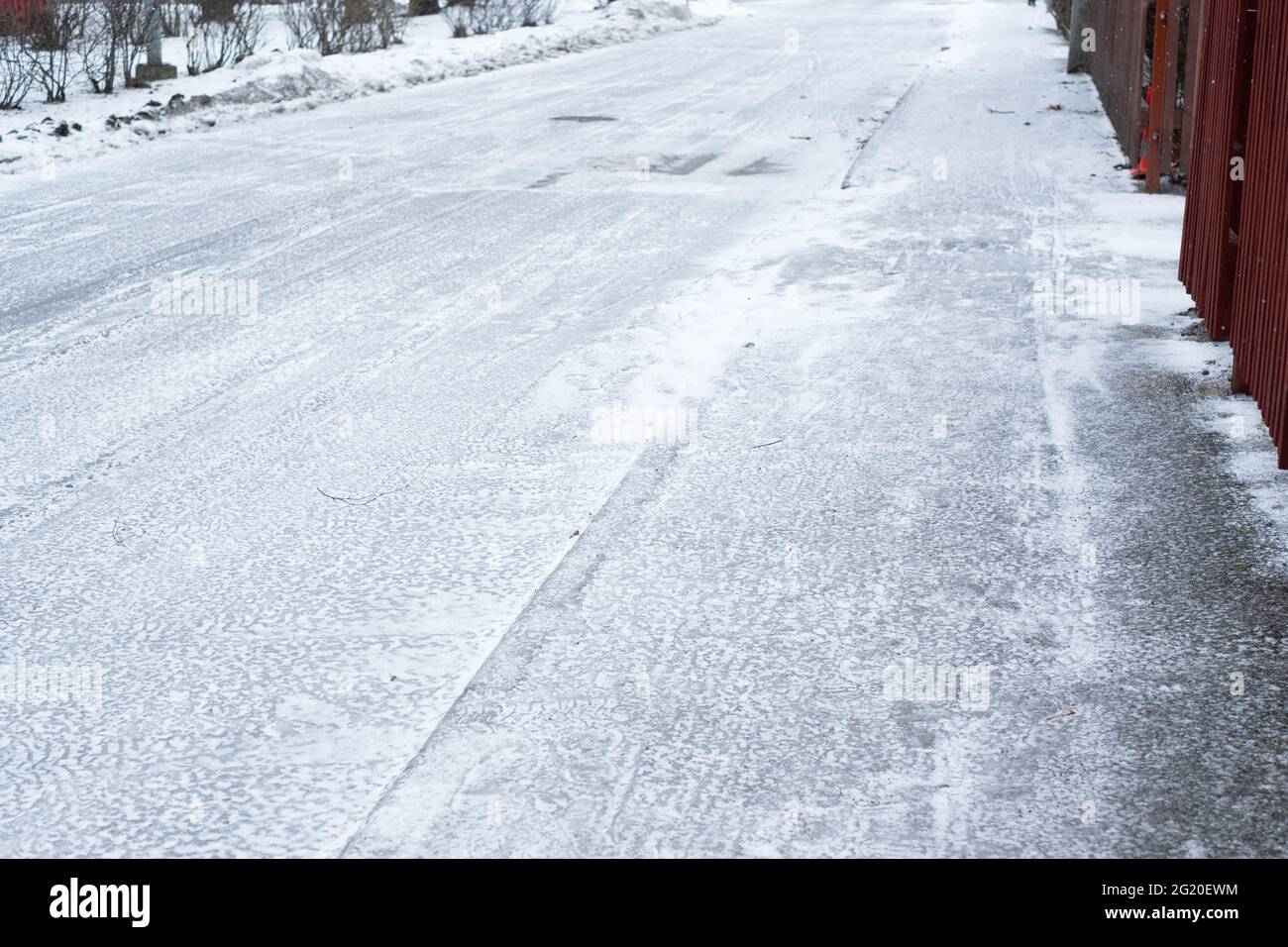 Strada ghiacciata e scivolosa coperta di ghiaccio durante l'inverno. Condizioni atmosferiche difficili. Foto Stock