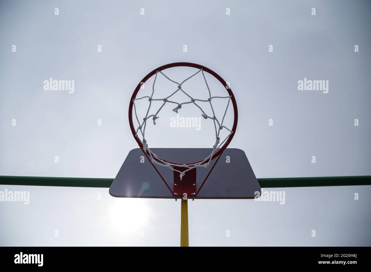 Foto dell'anello di pallacanestro in un giorno nuvoloso sulla strada Foto Stock