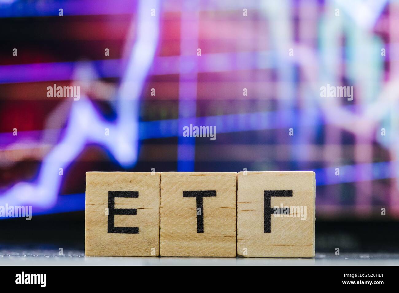 ETF Exchange-traded fondo lettere di legno e blurry classifiche del mercato azionario in background Foto Stock