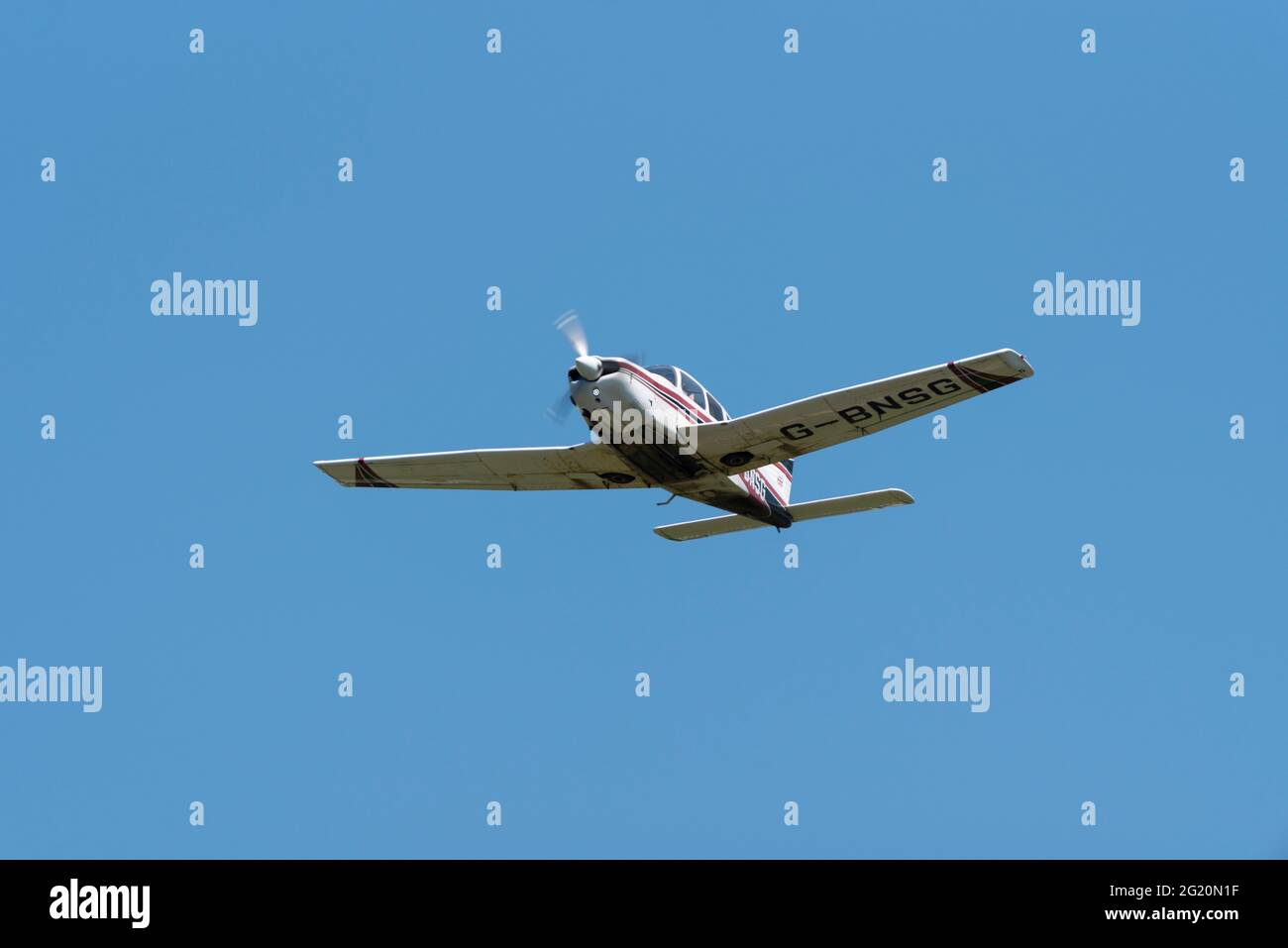 1978 Piper PA-28 aereo Cherokee Arrow III che vola in cielo azzurro sull'aeroporto di Southend, Essex, Regno Unito. Buona visibilità volo privato. Arrampicata Foto Stock