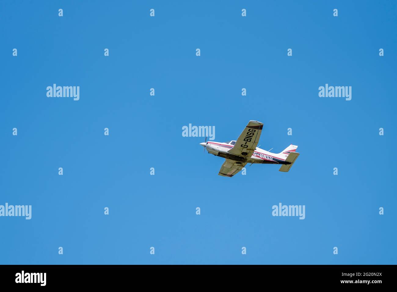 1978 Piper PA-28 aereo Cherokee Arrow III che vola in cielo azzurro sull'aeroporto di Southend, Essex, Regno Unito. Buona visibilità volo privato in VMC Foto Stock