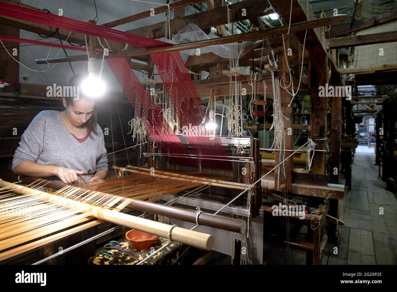Tradizionale laboratorio tessitori Bevilacqua, le donne lavorano su tessiture in legno d'epoca, producendo tessuti di lusso, a Venezia dal 1875 . Foto Stock