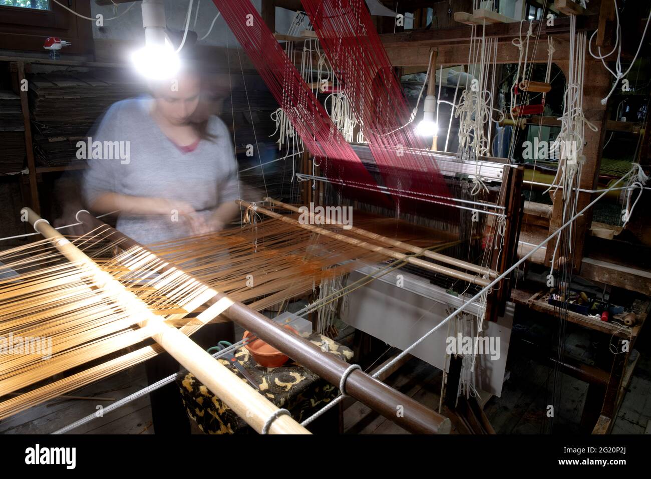 Tradizionale laboratorio tessitori Bevilacqua, le donne lavorano su tessiture in legno d'epoca, producendo tessuti di lusso, a Venezia dal 1875 . Foto Stock