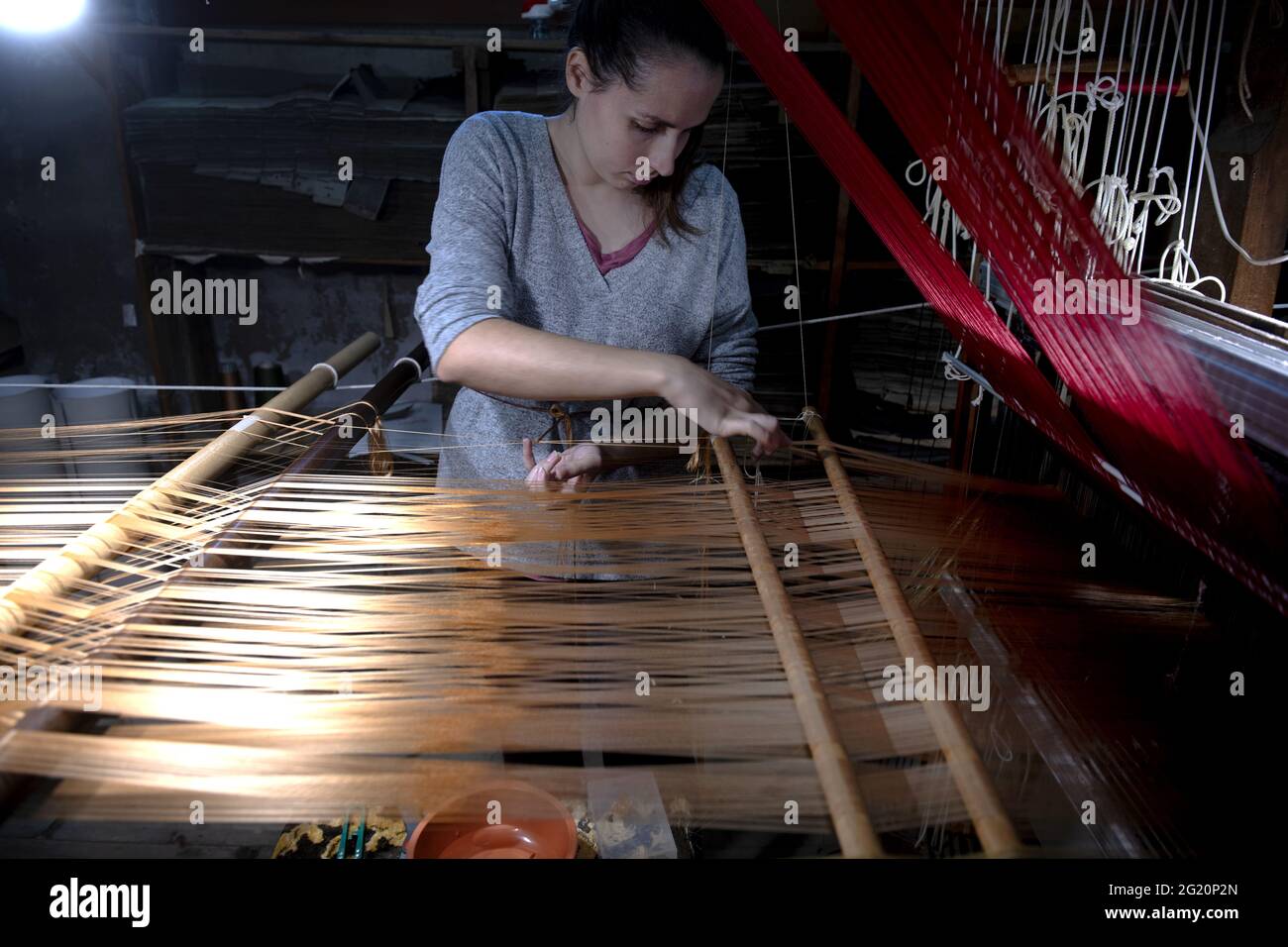 Tradizionale laboratorio tessitori Bevilacqua, le donne lavorano su tessiture in legno d'epoca, producendo tessuti di lusso, a Venezia dal 1875 . Foto Stock