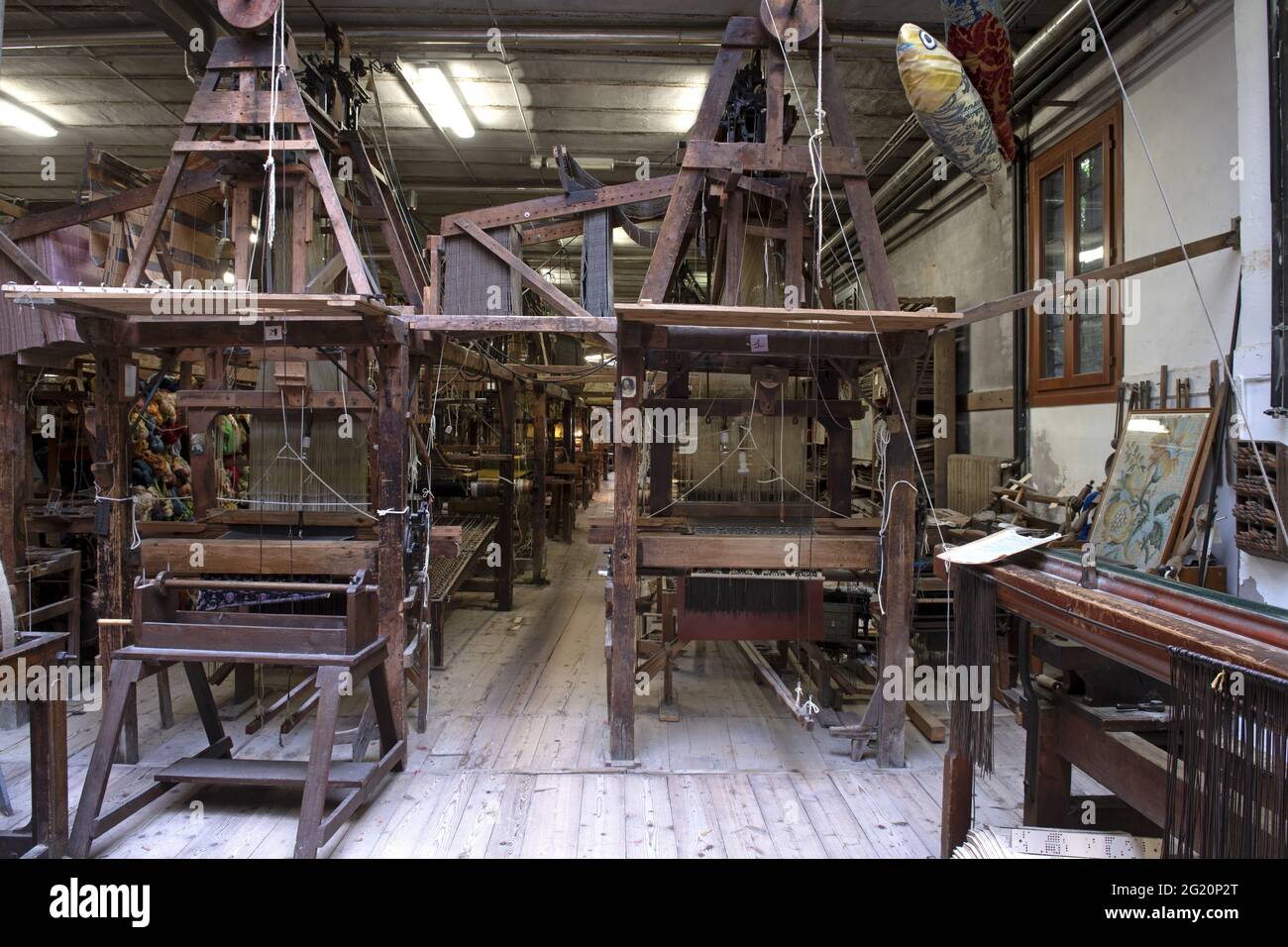 Tradizionale laboratorio tessitori Bevilacqua, le donne lavorano su tessiture in legno d'epoca, producendo tessuti di lusso, a Venezia dal 1875 . Foto Stock