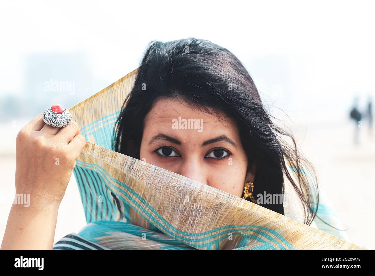 Giovane donna indiana ritratto in sari con il viso coperto. Bella donna musulmana indiana copre il suo viso con saree. Foto Stock