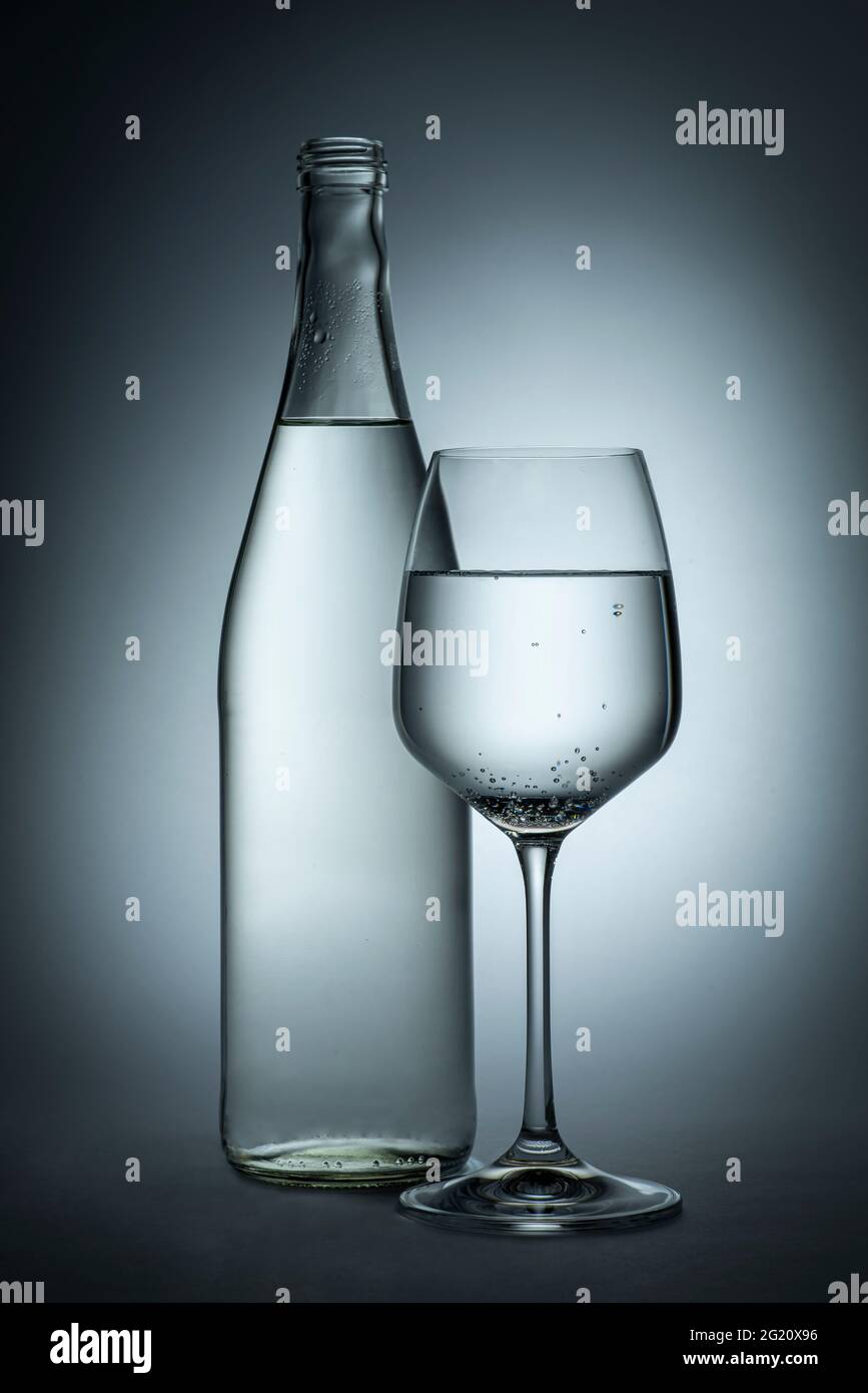Fotografia di una bottiglia e di un bicchiere d'acqua Foto Stock