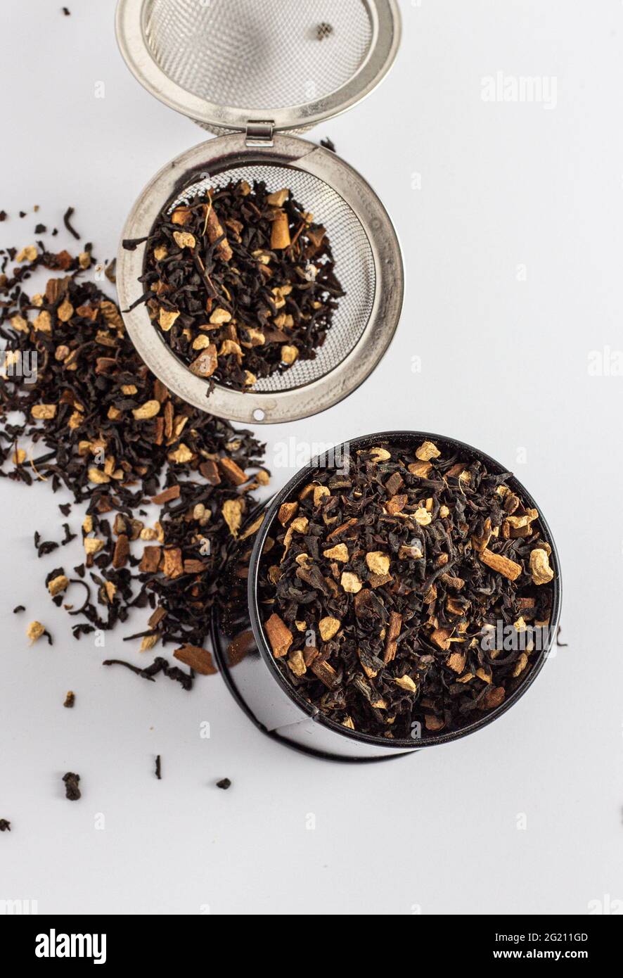 Foglie di tè Chai con piccoli pezzi di spezie su un infusore di tè Foto Stock