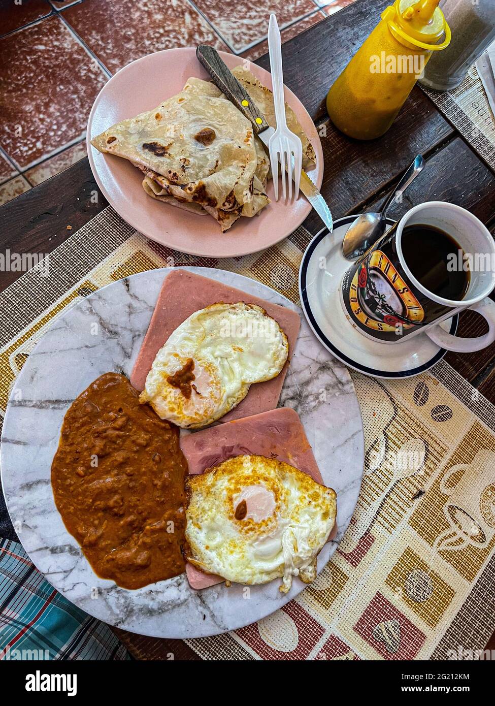 Due uova strapazzate su fette di prosciutto, fagioli e caffè americano in una tazza Guns and Roses al Cafe Cele nel mercato municipale di Hermosillo, Messico. Colazione, cibo, cibo, pasti, cibo. (Foto di Luis Gutierrez / Norte Photo) Dos huevos estrellados sobre rebanadas de jamon, frijoles y cafe americano en tasa de Guns and Roses en el Cafe Cele del mercado Municipal de Hermosillo, Messico. Desayuno, Alimentos, comida, Comidas, cibo. (Foto di Luis Gutierrez/ Norte Photo) Foto Stock