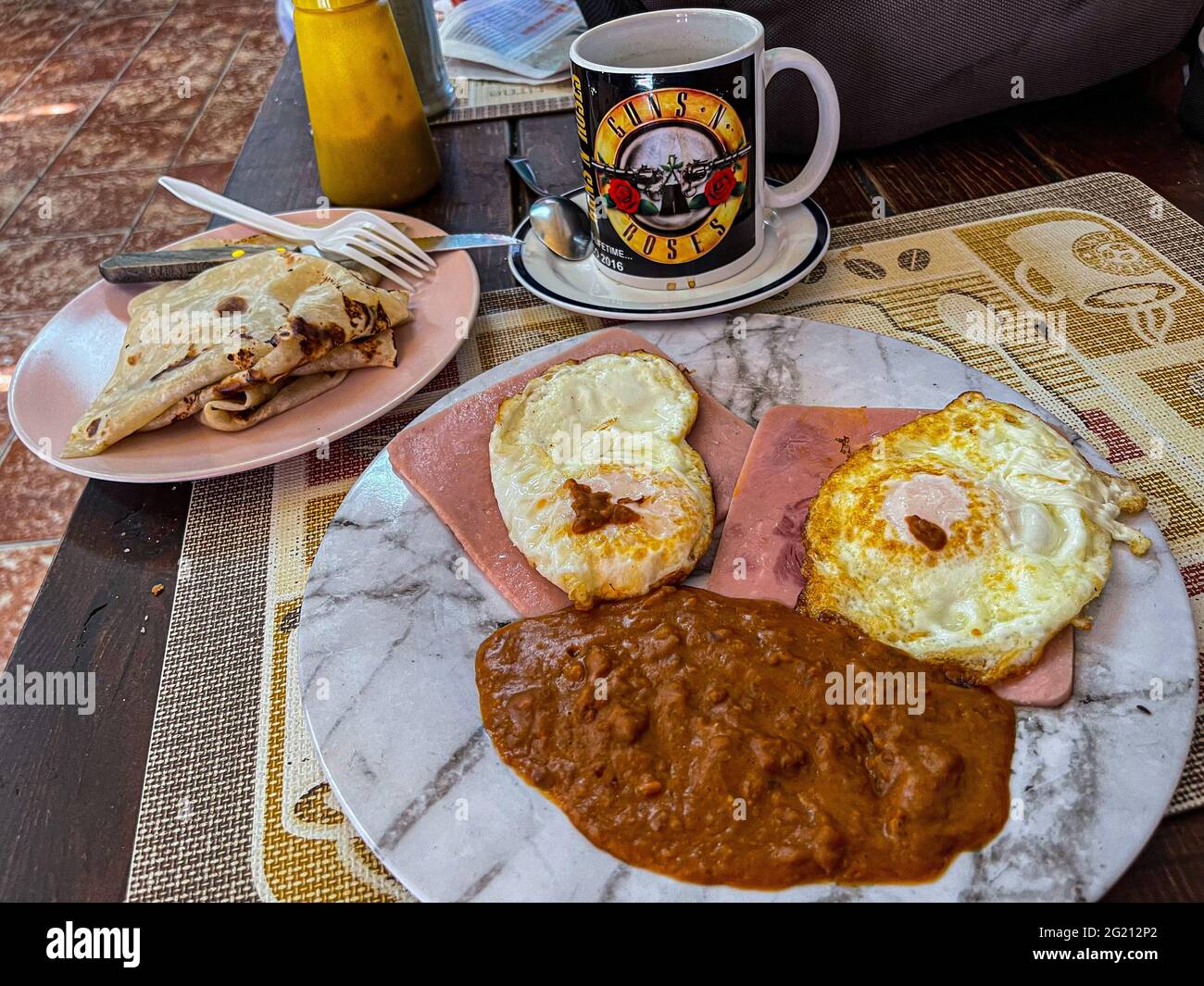 Due uova strapazzate su fette di prosciutto, fagioli e caffè americano in una tazza Guns and Roses al Cafe Cele nel mercato municipale di Hermosillo, Messico. Colazione, cibo, cibo, pasti, cibo. (Foto di Luis Gutierrez / Norte Photo) Dos huevos estrellados sobre rebanadas de jamon, frijoles y cafe americano en tasa de Guns and Roses en el Cafe Cele del mercado Municipal de Hermosillo, Messico. Desayuno, Alimentos, comida, Comidas, cibo. (Foto di Luis Gutierrez/ Norte Photo) Foto Stock