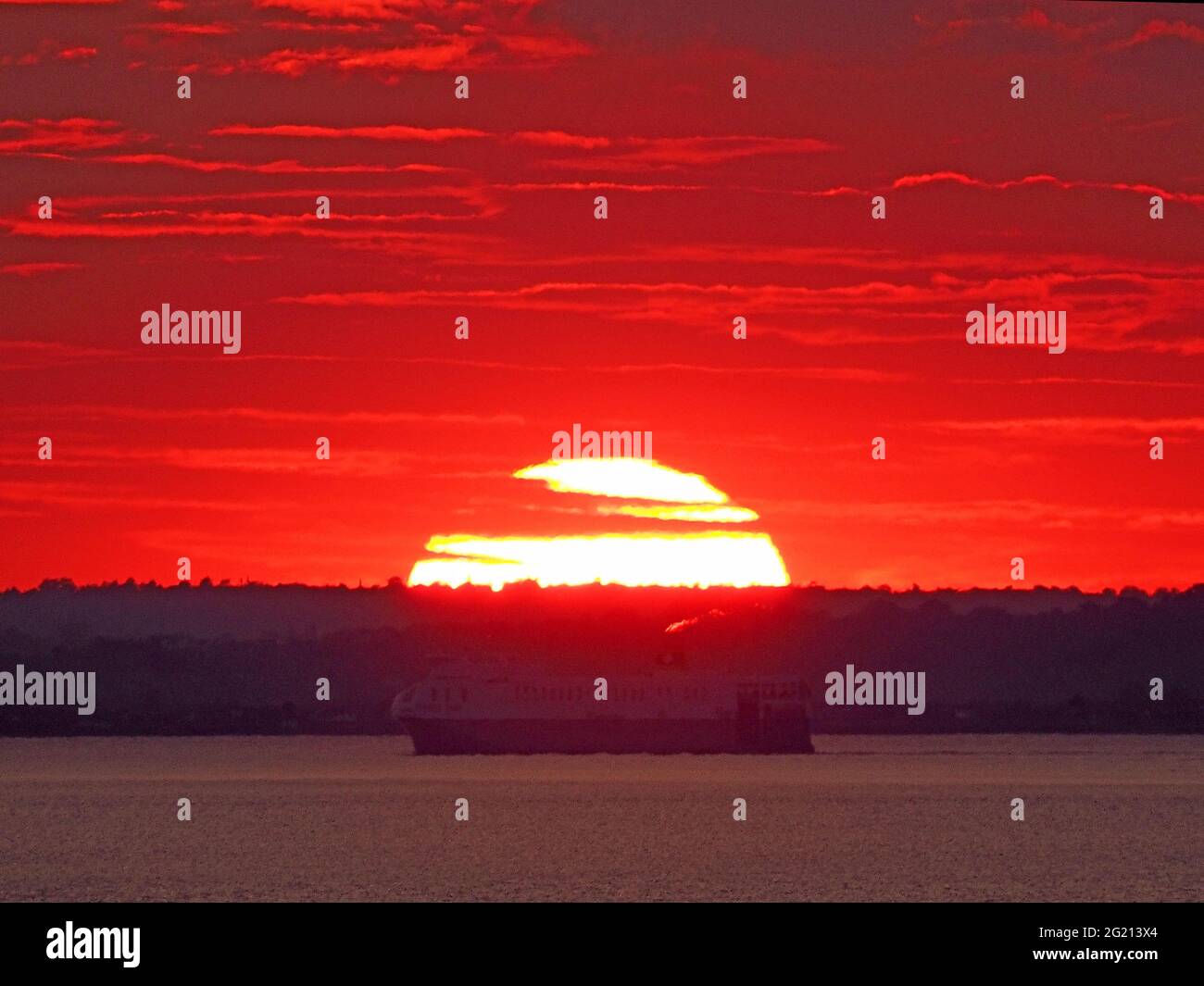 Minster on Sea, Kent, Regno Unito. 7 Giugno 2021. Regno Unito Meteo: Tramonto a onda di calore a Minster on Sea, Kent. La nave da carico RO-ro "Yasmine" che viaggia lungo il Tamigi passa il sole tramontante. Credit: James Bell/Alamy Live News Foto Stock