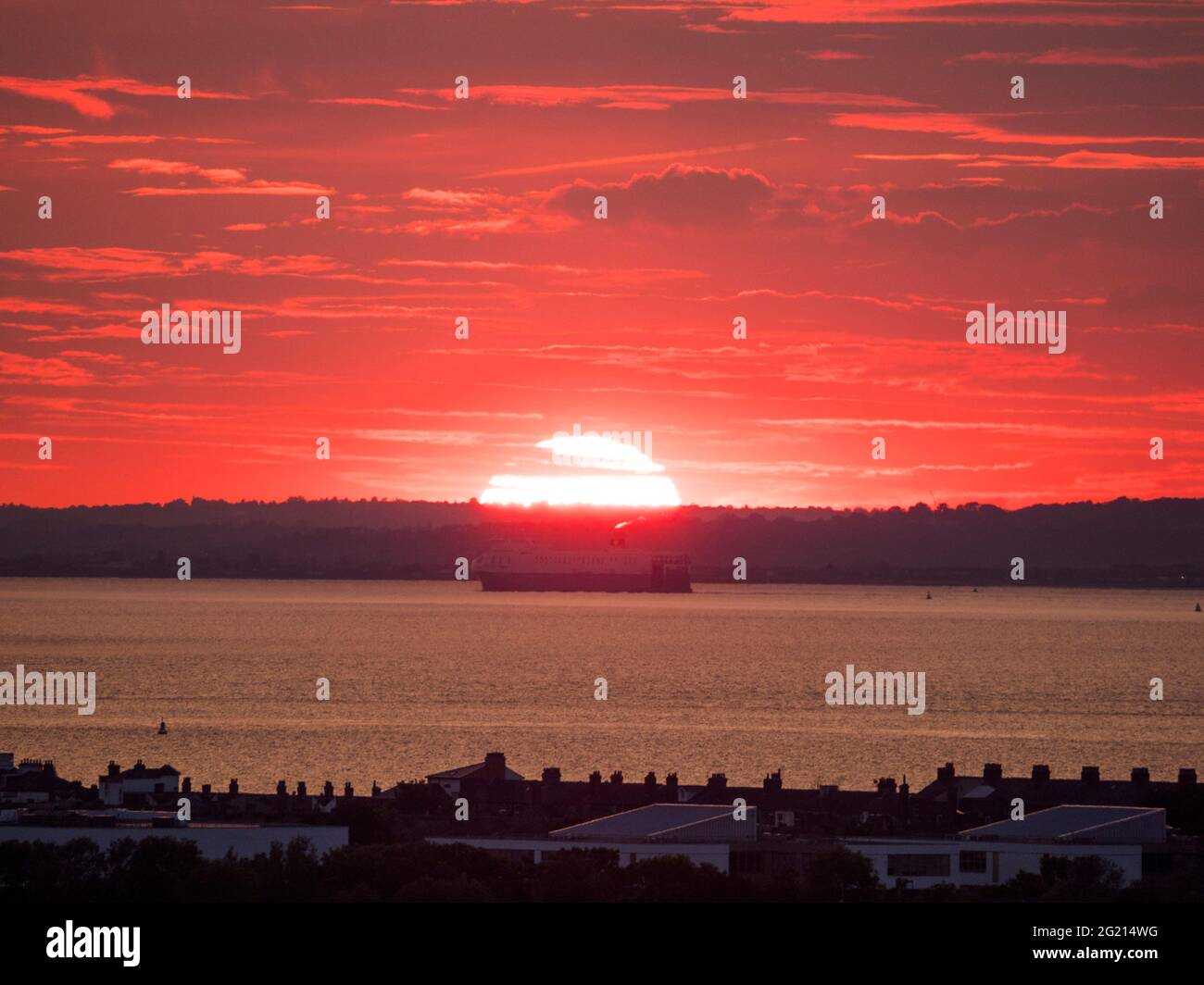 Minster on Sea, Kent, Regno Unito. 7 Giugno 2021. Regno Unito Meteo: Tramonto a onda di calore a Minster on Sea, Kent. La nave da carico RO-ro "Yasmine" che viaggia lungo il Tamigi passa il sole tramontante. Credit: James Bell/Alamy Live News Foto Stock
