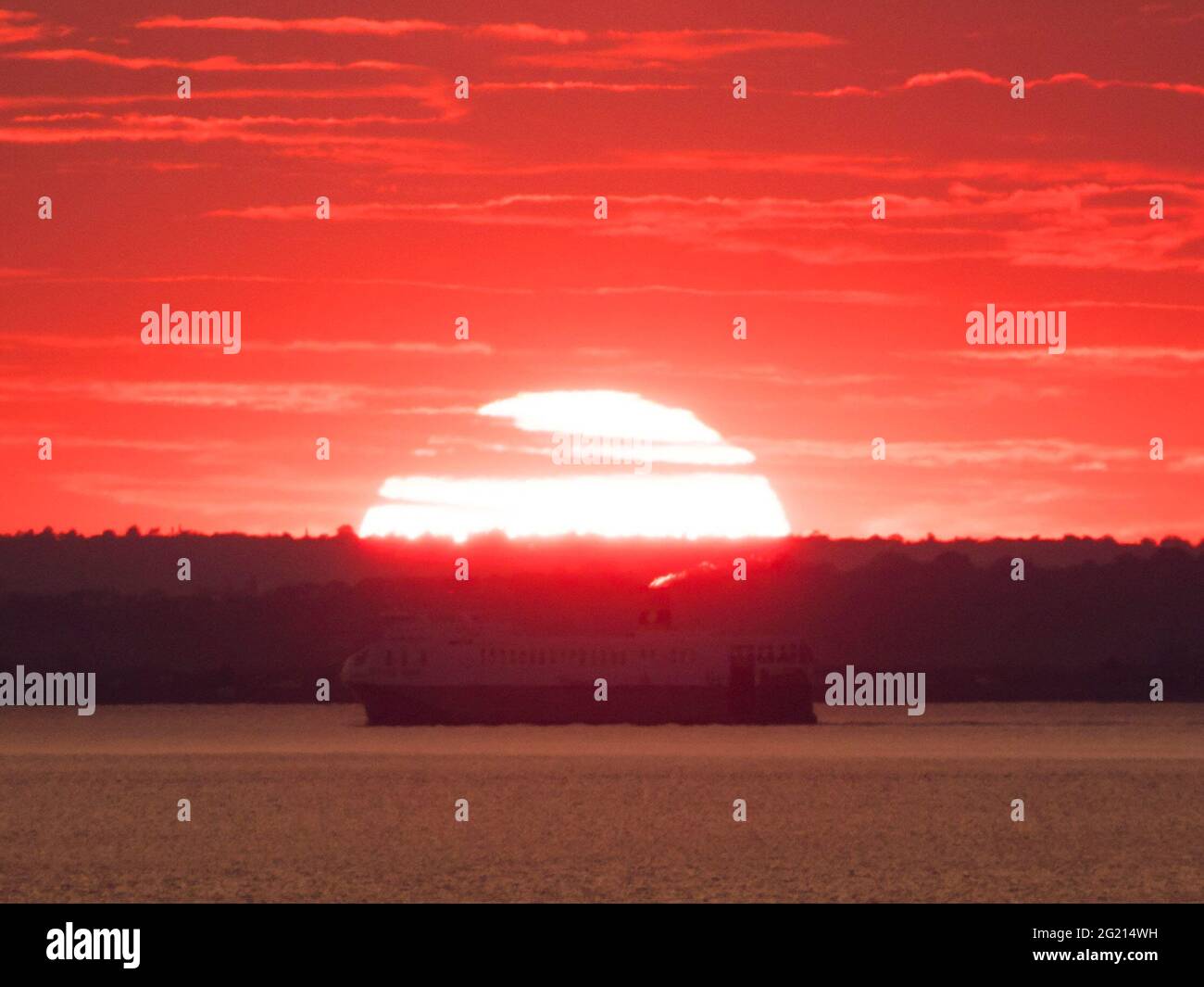Minster on Sea, Kent, Regno Unito. 7 Giugno 2021. Regno Unito Meteo: Tramonto a onda di calore a Minster on Sea, Kent. La nave da carico RO-ro "Yasmine" che viaggia lungo il Tamigi passa il sole tramontante. Credit: James Bell/Alamy Live News Foto Stock