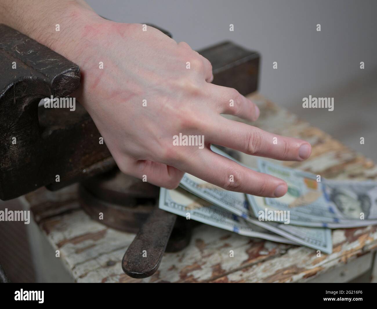 Mani afferrato in un vecchio vizio sta raggiungendo per il denaro. Concetto di avidità, onere fiscale, tasse pesanti Foto Stock
