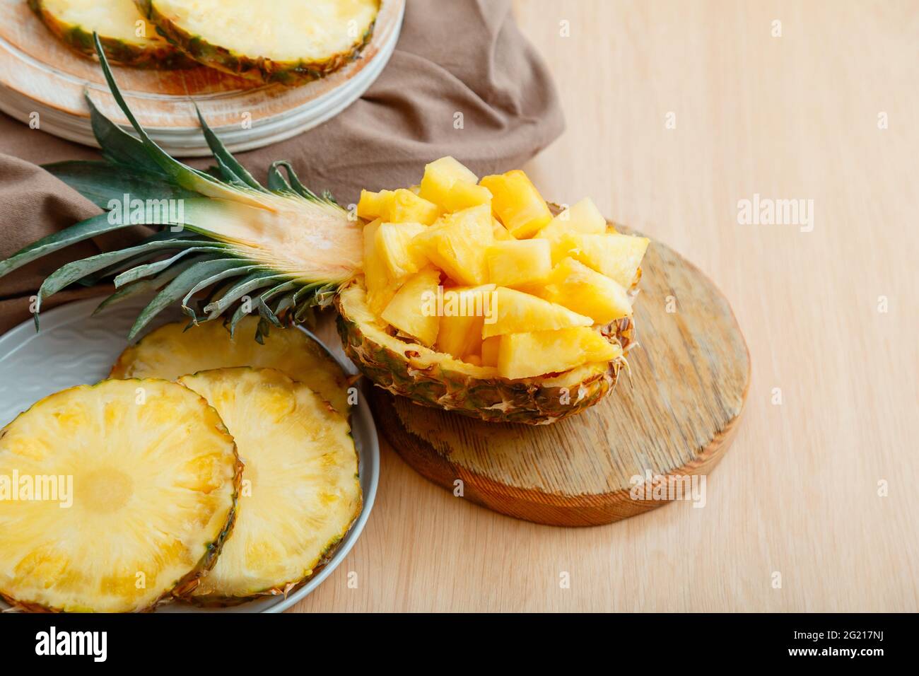 Insalata di ananas tritata in mezzo ananas. Fresco delizioso ananas tagliato a pezzi. Gustoso dessert estivo con frutta a fette di ananas e ingredienti Foto Stock