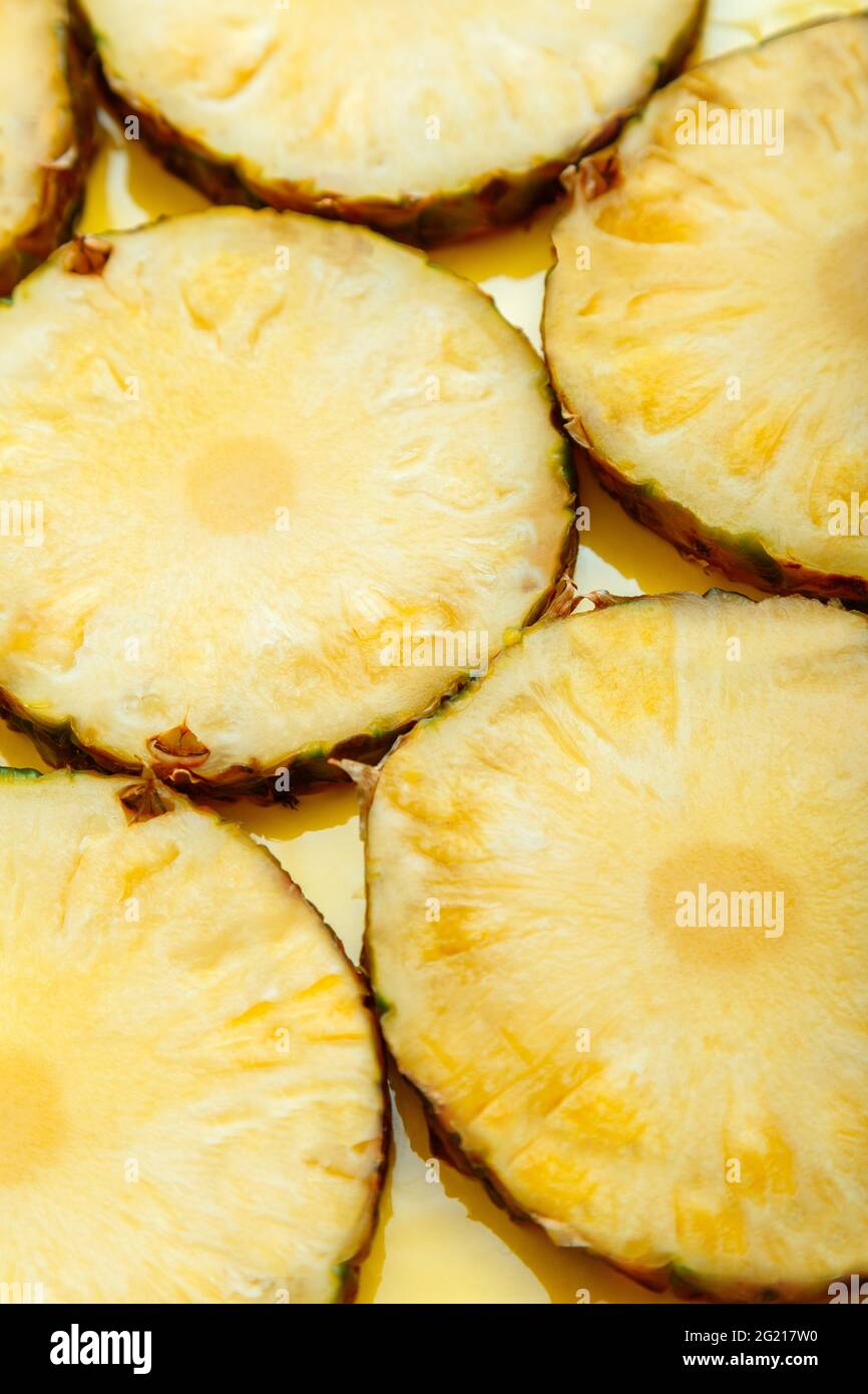 Cerchietti ananas sfondo. Cibo frutta tropicale giallo estate fondo texture superficie. Modello di ananas. Verticale Foto Stock