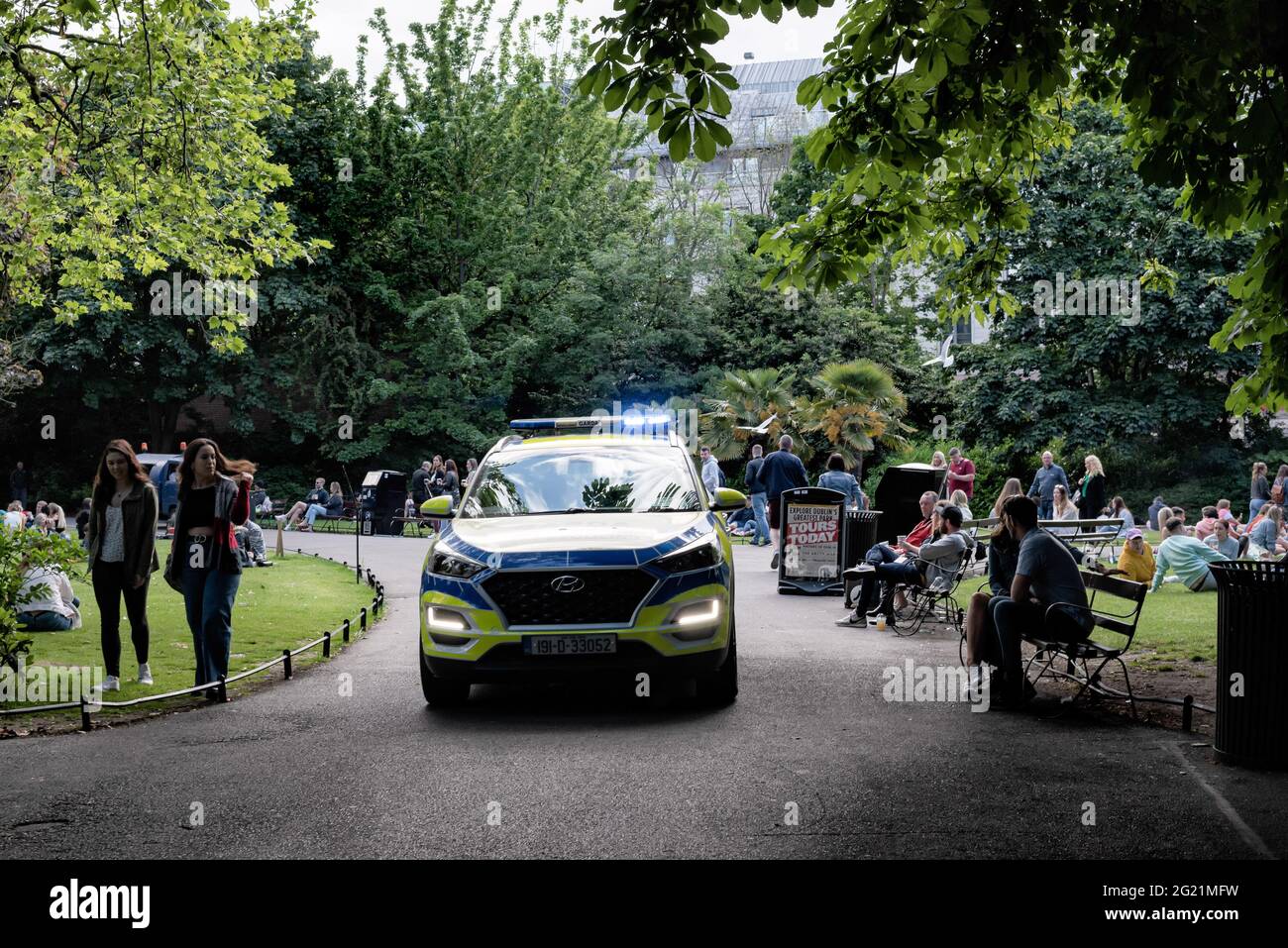 Un veicolo di polizia pattugliano la strada come persone, rilassarsi nel Parco Verde di Stephen. Dall'aprile 2021, Dublino ha gradualmente attenuato le restrizioni, e con la festa della banca in calo lunedì 7 giugno, il riscaldamento del tempo, e i servizi igienici pubblici installati nelle strade, diverse persone hanno scelto di trascorrere il fine settimana socializzando all'aperto nel centro della città. La grande folla ha provocato tensioni come le bottiglie che sono state gettate alla polizia, le persone che si rifiutano di trasferirsi quando la polizia li ha richiesti, e altri incidenti che hanno portato a 47 arresti fino ad oggi. (Foto di Natalia Campos/SOPA Images/Sipa Foto Stock