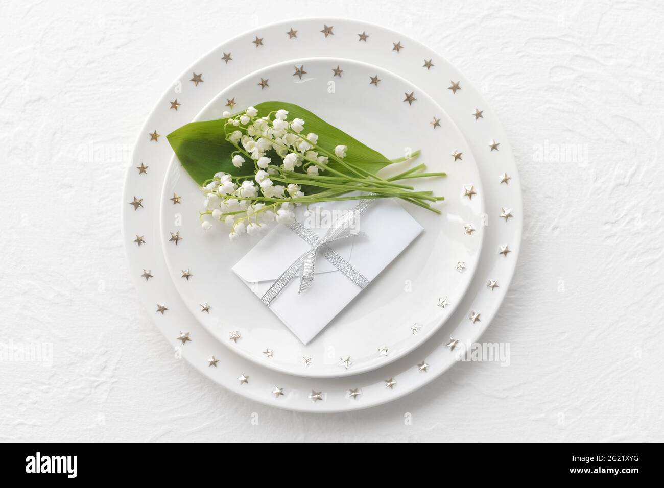 Bella tavola con fiori giglio-della-valle su sfondo chiaro Foto Stock