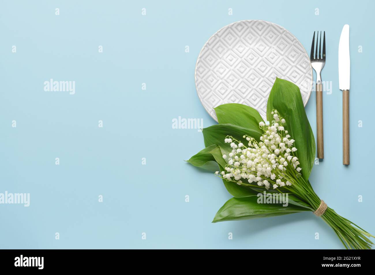 Bella tavola con fiori giglio-della-valle su sfondo a colori Foto Stock