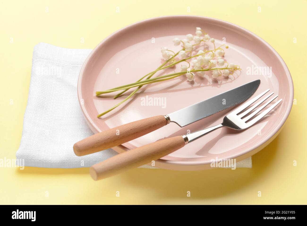 Bella tavola con fiori giglio-della-valle su sfondo a colori Foto Stock