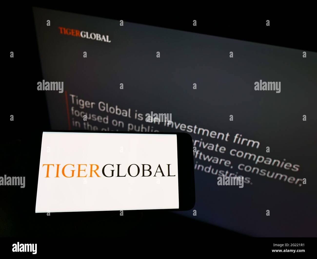 Persona che tiene il telefono mobile con il logo della ditta americana di investimento Tiger Global Management LLC sullo schermo davanti alla pagina web. Mettere a fuoco il display del telefono. Foto Stock