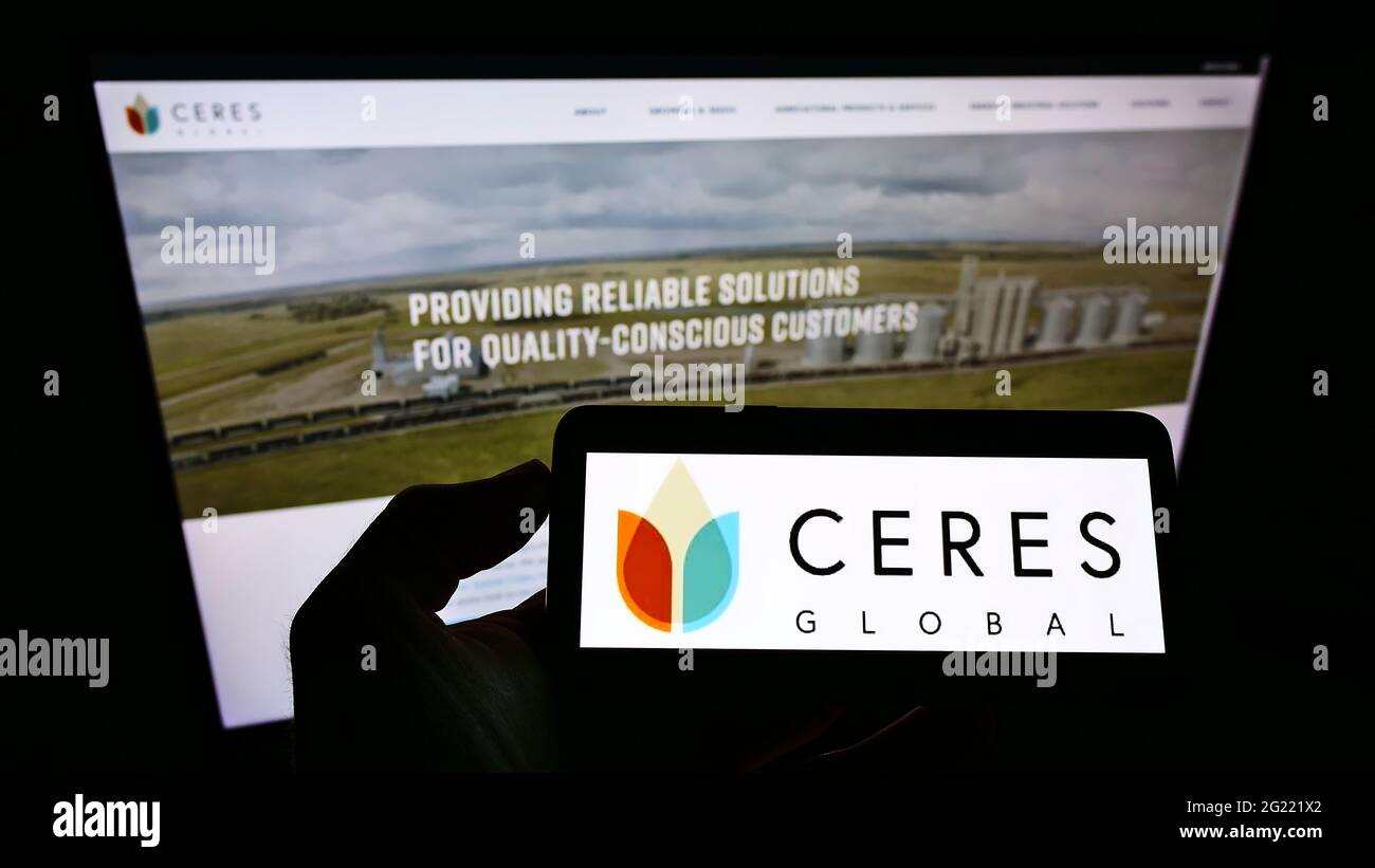 Persona che detiene smartphone con il logo della società agricola americana Ceres Global AG Corp. Sullo schermo davanti al sito Web. Mettere a fuoco il display del telefono. Foto Stock