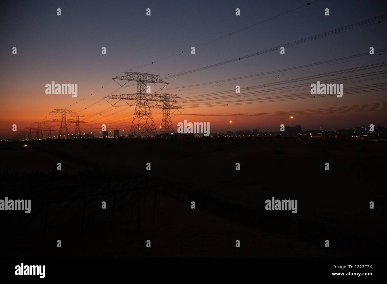 La trasmissione torreggia nel deserto di Dubai subito dopo il tramonto, quando l'ultimo del sole si illumina ancora nel cielo arancione. Foto Stock
