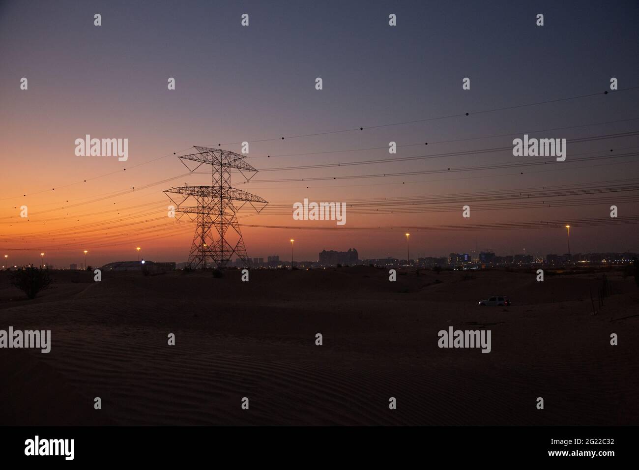 La trasmissione torreggia nel deserto di Dubai subito dopo il tramonto, quando l'ultimo del sole si illumina ancora nel cielo arancione. Foto Stock