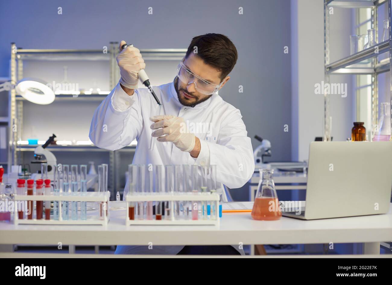 Scienziato serio che lavora da solo in un laboratorio scientifico di un'azienda farmaceutica o biotecnologica Foto Stock