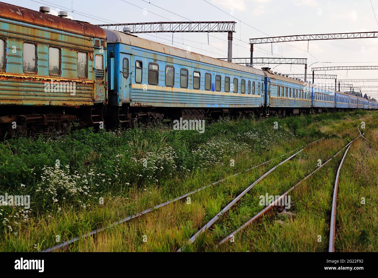Trasporto - vista laterale sulle vecchie vetture ferroviarie passeggeri con i finestrini rotti. Foto Stock