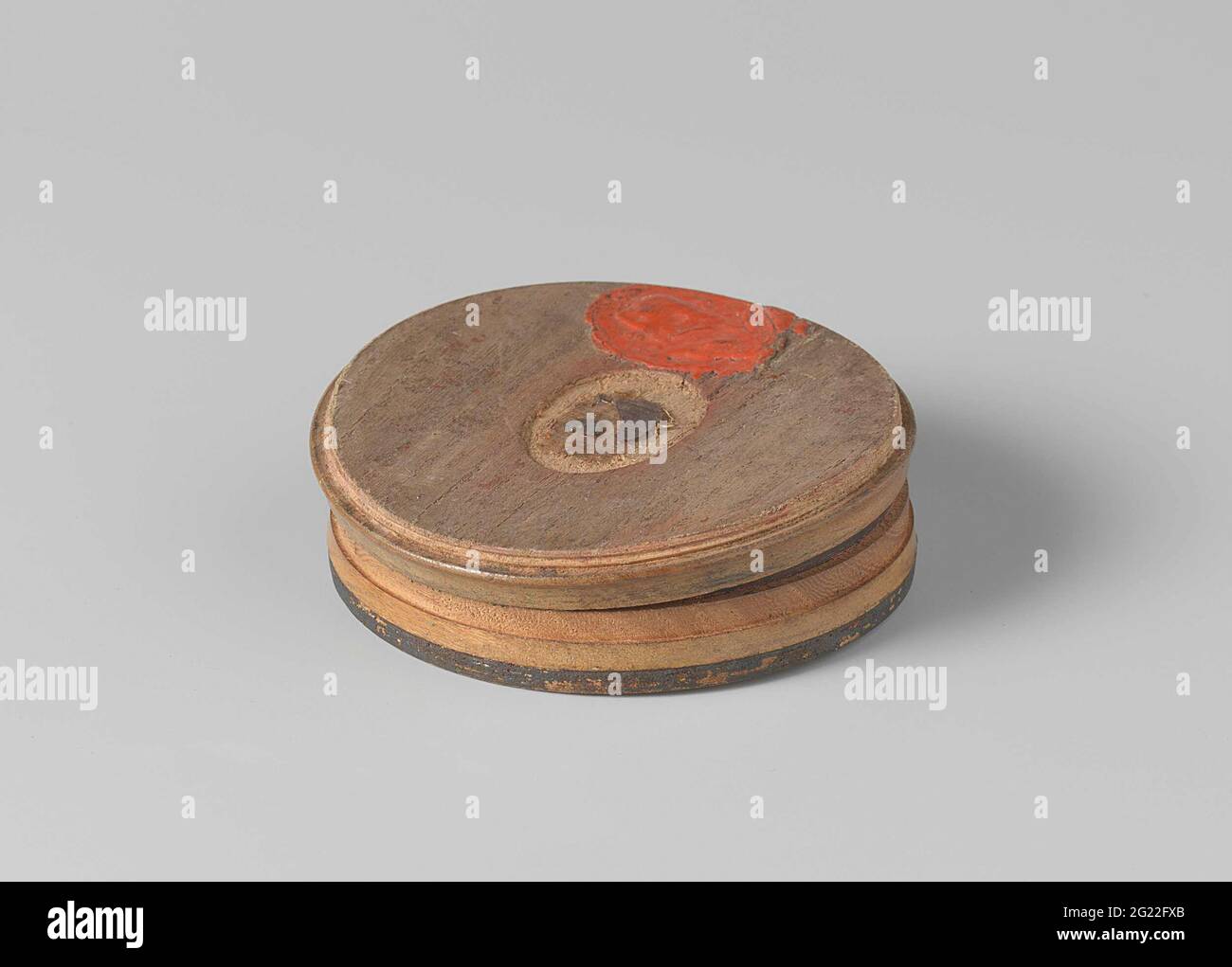Scatola di snuff fatta dal legno della nave di Van Speijk. Scatola rotonda  in legno tornita con bordo rosso e nero e dall'interno tartaruga rossa /  nera / marrone (?). Scatola di