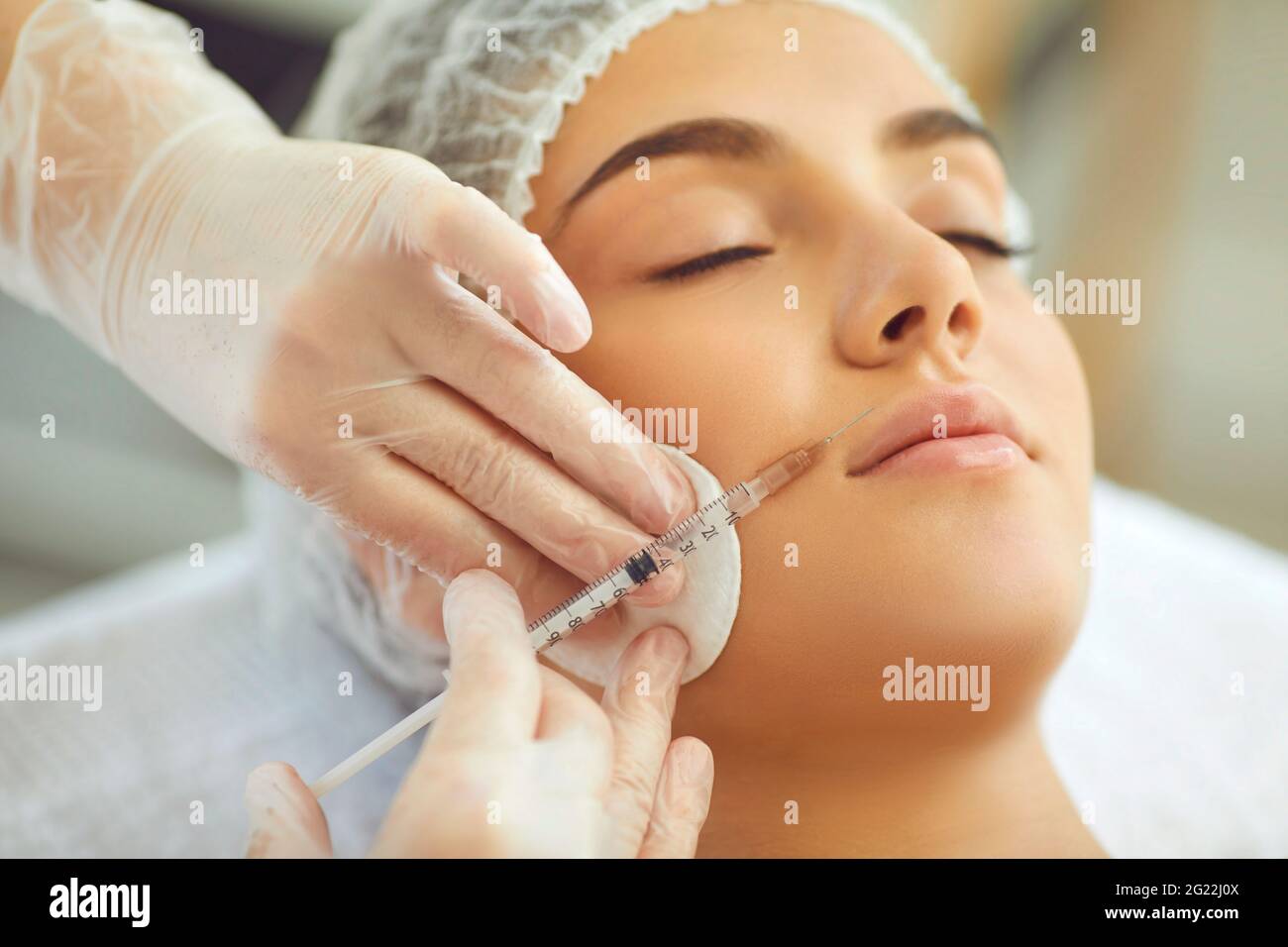Iniezioni di bellezza sulle labbra. Cosmetologia e cura professionale della pelle. Donna in salone di bellezza. Foto Stock