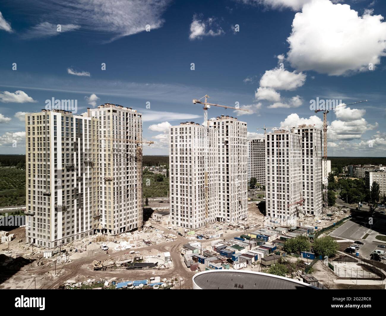 Luminosa foto aerea del cantiere. Nuove case con gru da costruzione. Sviluppo urbano Foto Stock