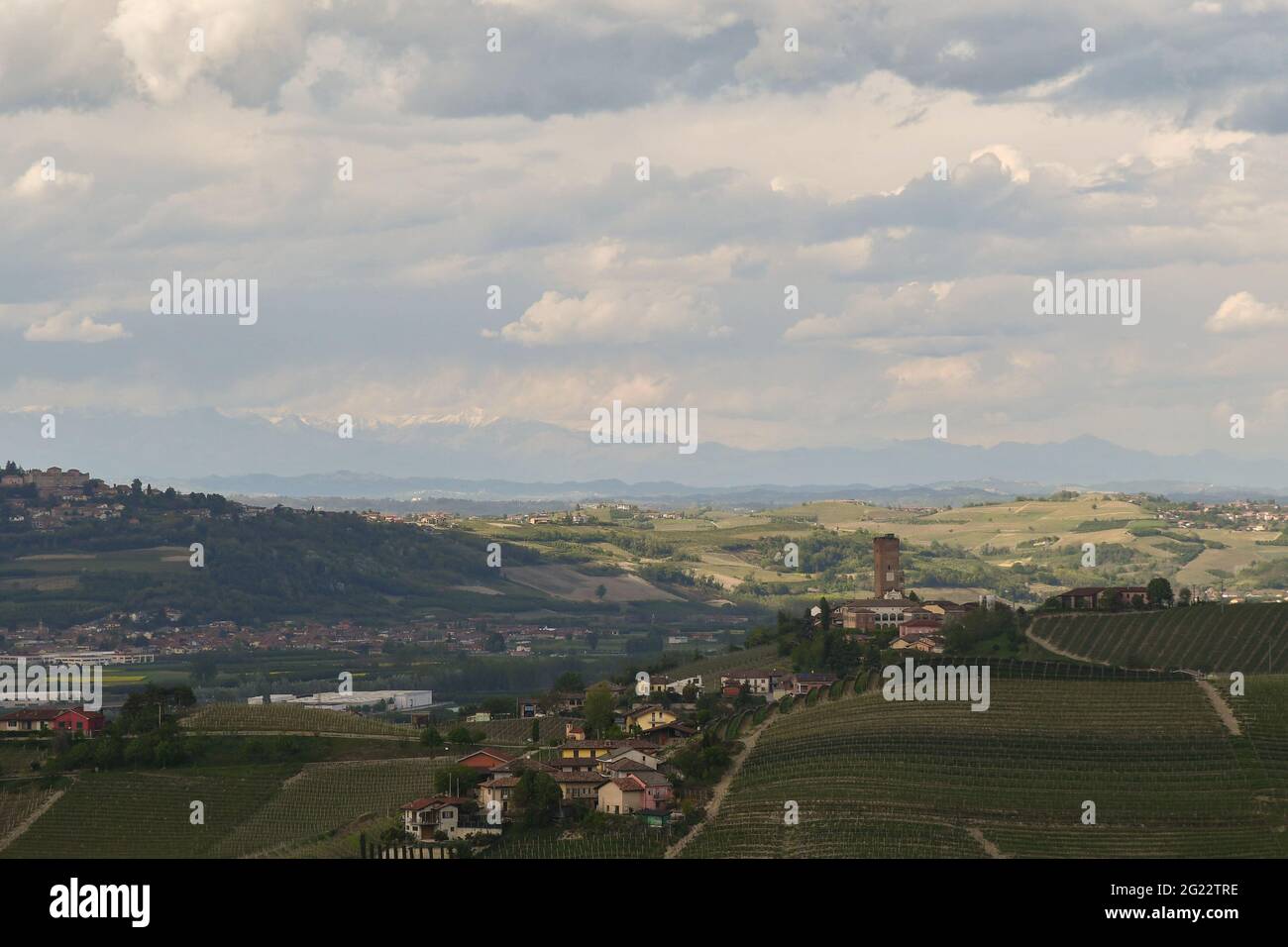 Vista panoramica sulle colline dei vigneti delle Langhe, patrimonio dell'umanità dell'UNESCO, con il borgo medievale di Barbaresco in una nuvolosa giornata di primavera, Cuneo, Piemonte, Italia Foto Stock
