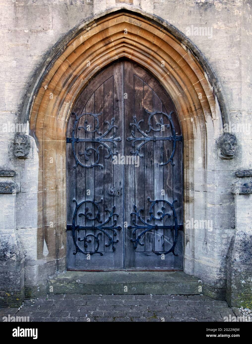 Grande porta ad arco decorata nella Cattedrale di Arundel, con teste scolpite su entrambi i lati; Arundel, West Sussex, UK Foto Stock