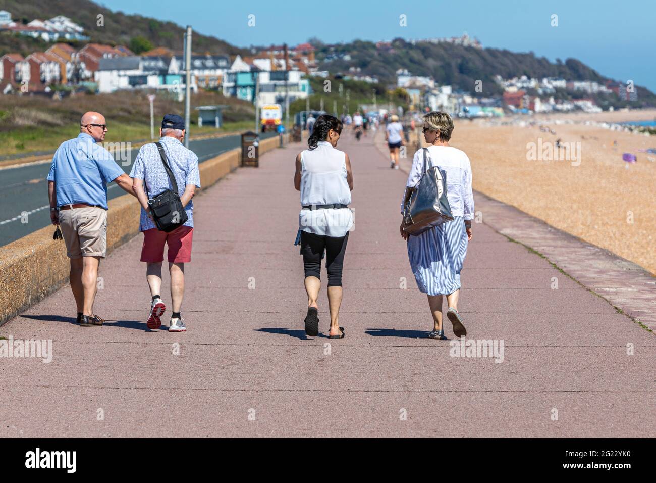 Due coppie passeggiano lungo la Parata del Principe, Hythe, Kent, in una calda giornata di sole. Foto Stock